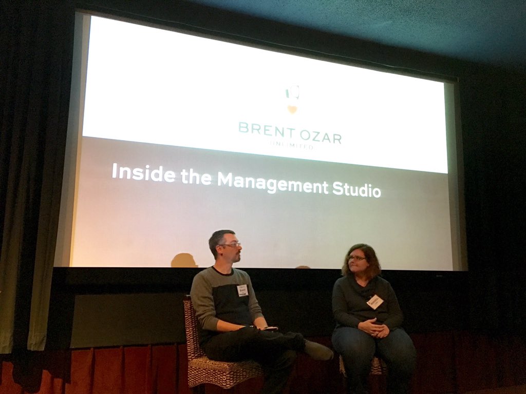 Brent Ozar and Kendra Little seated beneath an Inside the Management Studio slide at FreeCon.