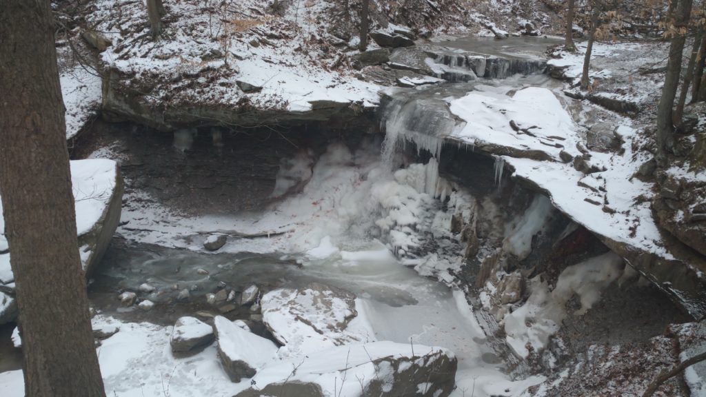 Blue Hen Falls flows over a rocky ledge in winter.