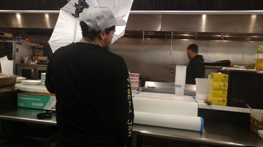 A chef photographs a brunch dish at the kitchen counter.