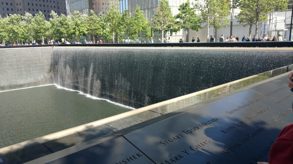 Trees surround a reflecting pool at the World Trade Center memorial.