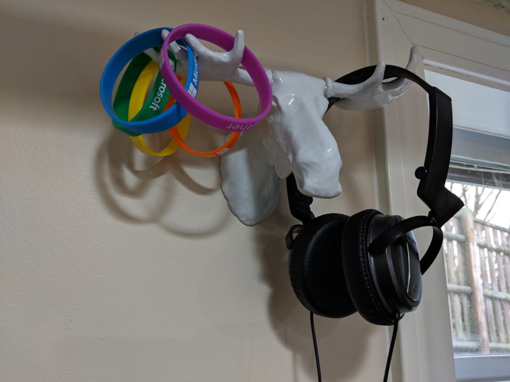Wall-mounted moose antlers holding headphones and bracelets.