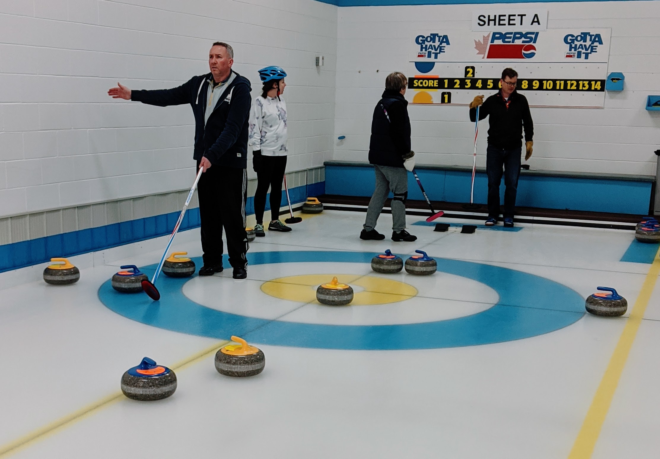 Aaron attempts a stone split during a curling match.